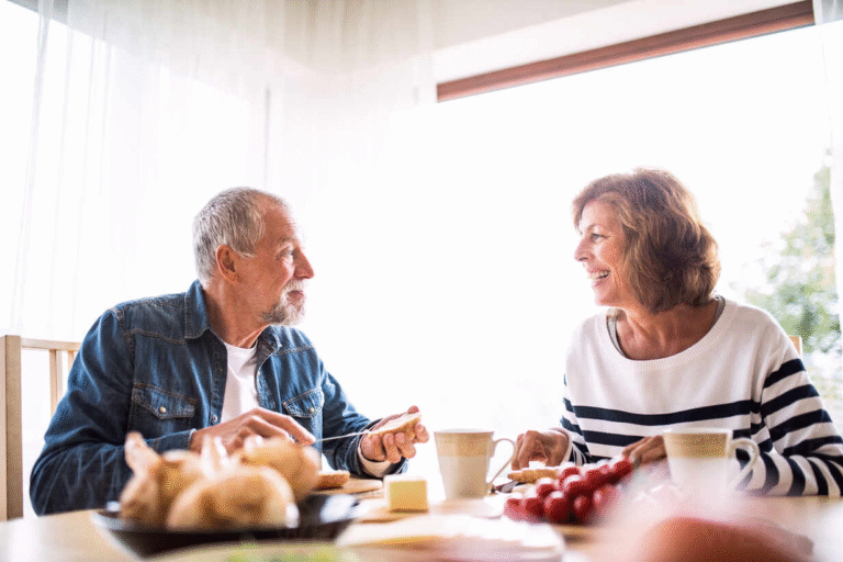 happy senior couple enjoying financial freedom at breakfast table