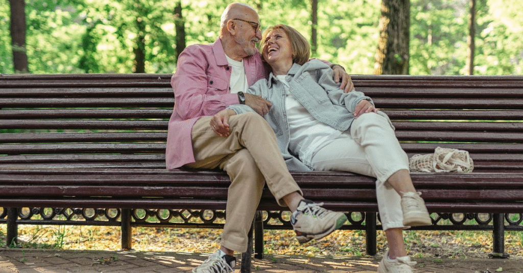 Elderly couple sitting on a bench lovingly looking at each other, symbolizing family unity and lasting legacy.