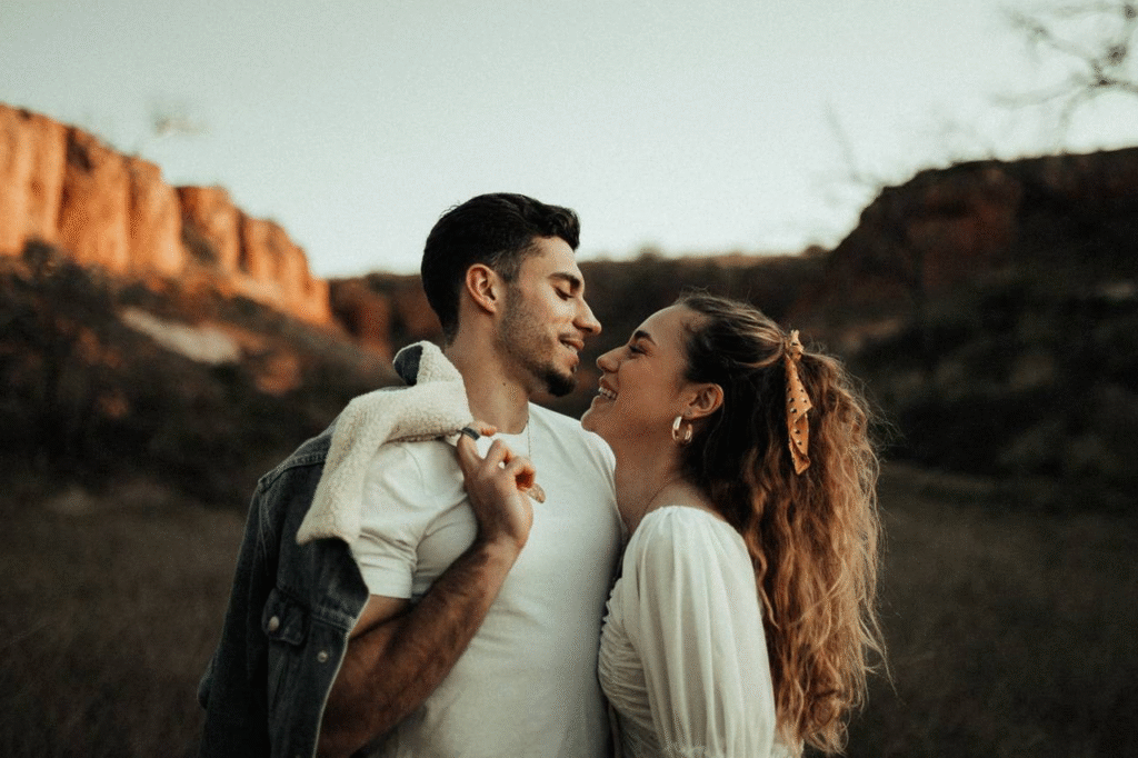 Happy couple standing together smiling, representing love, success, and the journey to create wealth.
